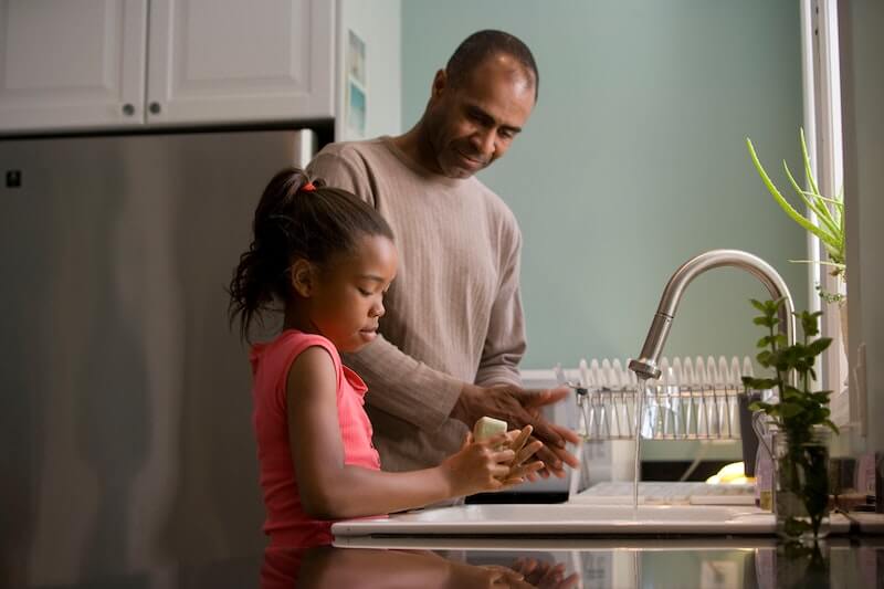 dad and daughter cleaning dishes together